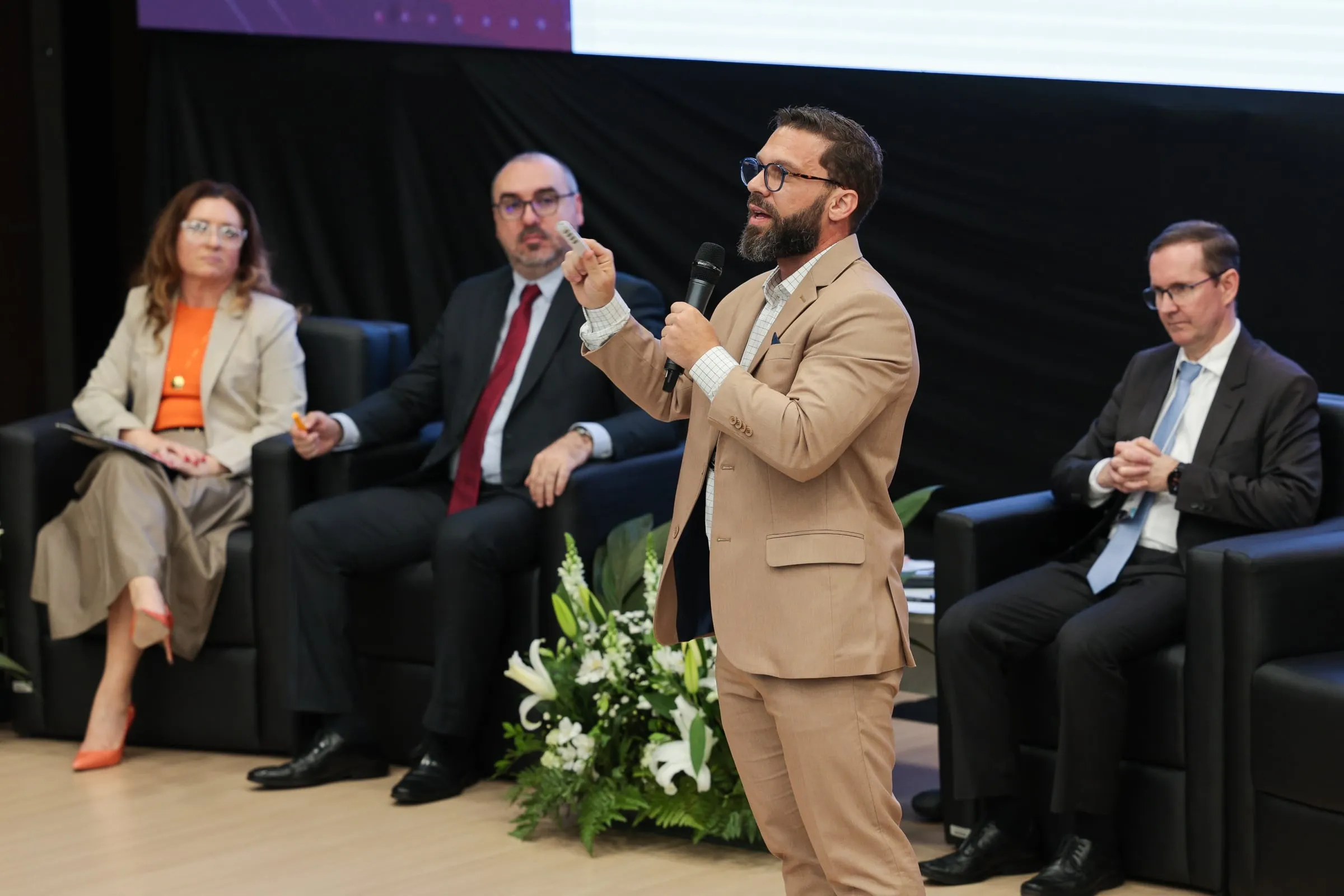 Filipe Ivo de terno bege explica um ponto ao microfone na Jornada Data-Driven do TJSC, diante da mesa de autoridades